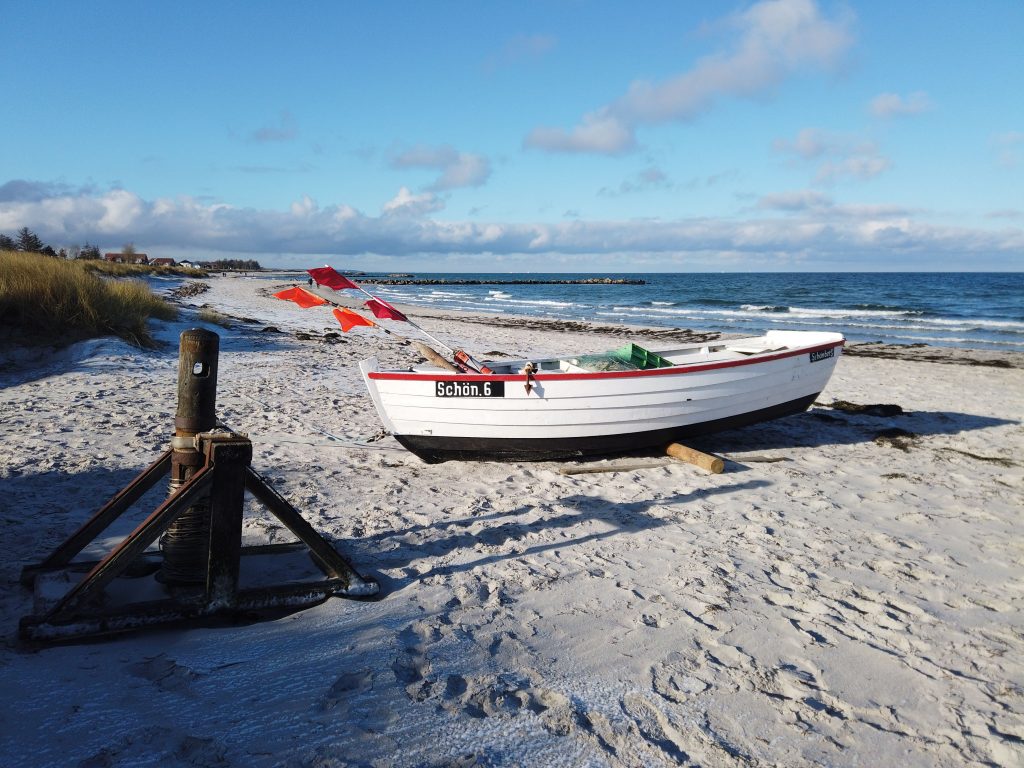 Ruderboot liegt auf dem Strand bei sonnigem Wetter